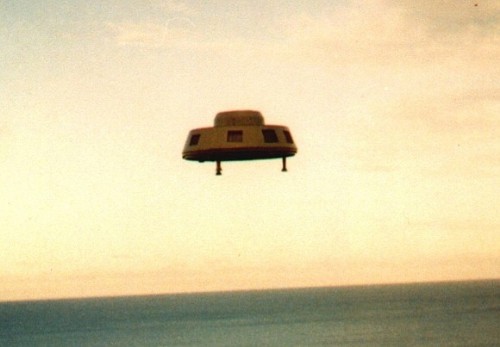 Original 1993 photograph by Eric Thomason of a metallic disc-shaped UFO hovering over the ocean at Maslin Beach, Australia.